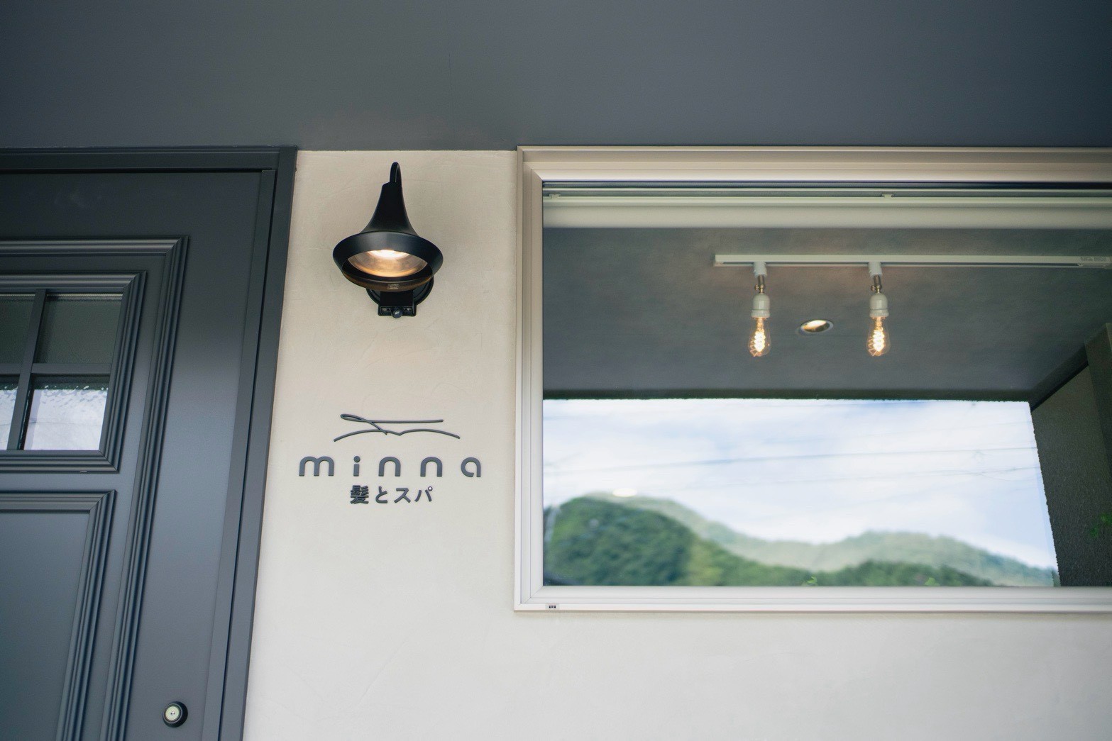 minnaの看板と、窓に映る若穂の山並み